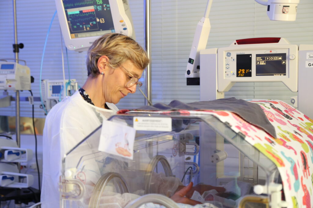 Photo d'une puéricultrice s'occupant d'un bébé en couveuse