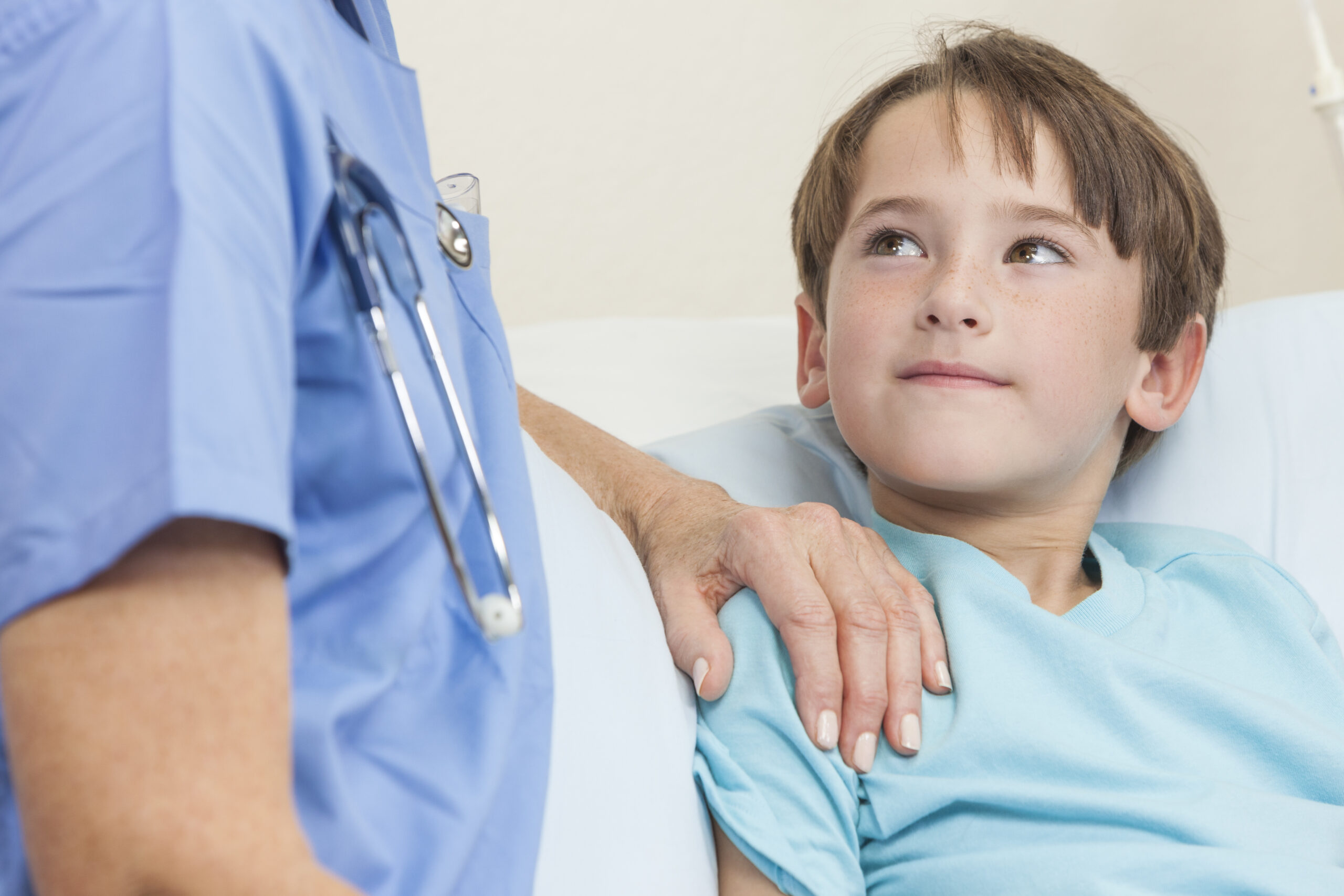 Infirmière réconfortant un jeune enfant dans un lit d'hôpital