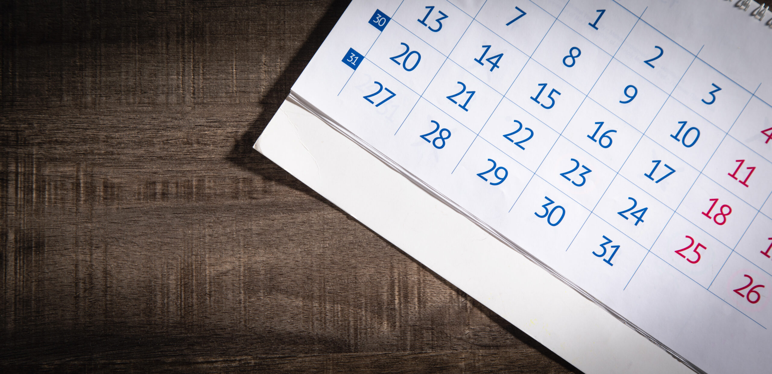 Photo d'un calendrier papier sur un bureau en bois